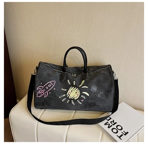 Detail of canvas travel bag with colorful graffiti art, dual handles and wide shoulder strap