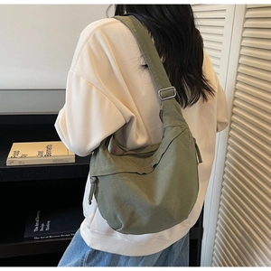 Détail du sac hobo en toile vert armée montrant la boucle réglable et la texture du tissu
