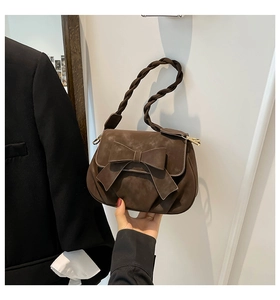 Dettaglio della borsa vintage marrone con grande fiocco e tracolla intrecciata