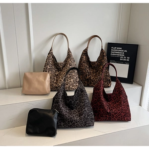 Detail view of large leopard print hobo bags and matching pouches on white tiered display