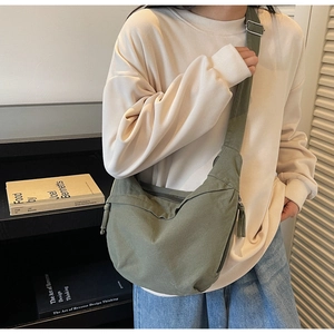 Détail du sac bandoulière demi-lune en toile vert olive avec sangle réglable sur modèle