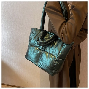 Detailed side view showing metallic quilted texture and green nylon fabric of tote bag