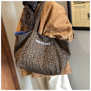 Detail of leopard print canvas tote bag featuring large capacity and brand lettering