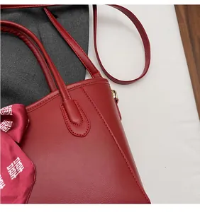 Dettaglio della borsa tote in pelle rossa con trama a grana e cuciture rifinite a mano
