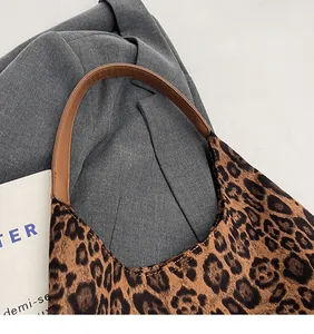Close-up of leopard print tote bag showing reinforced brown leather handle stitching