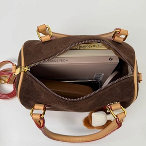 Top view of brown suede cylinder bag with leather straps and red edge paint detail
