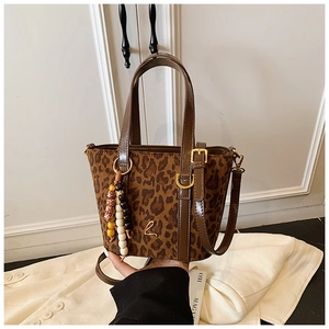 Dettaglio borsa shopper leopardata con finiture in vernice marrone e logo L in oro
