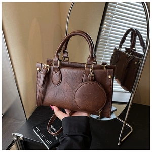 Detail of vintage dark brown tote bag with textured faux leather and round coin purse