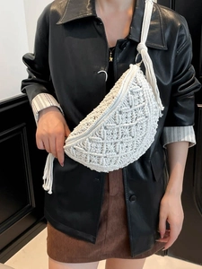 White bohemian woven half-moon crossbody bag with tassel and intricate knit patterns