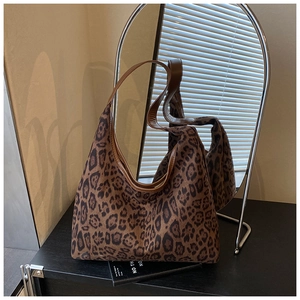 Detail of vintage leopard print tote bag with brown leather strap and mirror reflection
