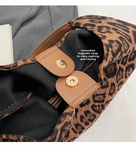 Detail of the magnetic closure and leather strap on this leopard print bucket bag
