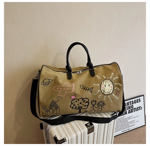 Close-up of olive green travel bag with colorful hand-drawn graffiti on a white suitcase
