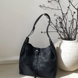 Detail of a vintage black hobo bag with a matte texture and silver buckle strap