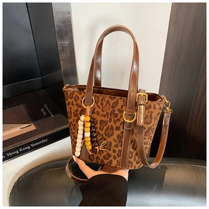 Dettaglio della borsa a secchiello leopardata con logo L dorato e nappa di perline