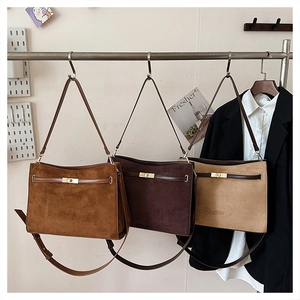 Close-up of frosted suede shoulder bags in caramel and coffee with metal twist locks
