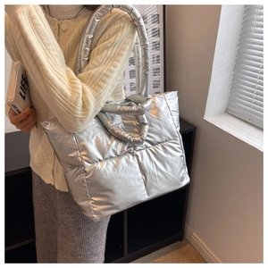 Detail of silver quilted puffer tote bag with metallic finish and spacious interior
