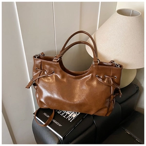 Detailed view of brown PU leather tote bag with drawstring and detachable shoulder strap