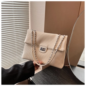 Dettaglio della borsa a tracolla in velluto beige con trama verticale e chiusura argento