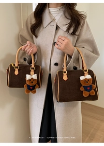Detail of vintage matte brown Boston bags with teddy bear charms and handles
