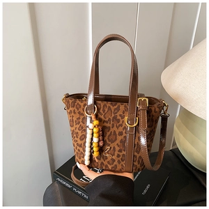 Dettaglio borsa leopardata in ecopelliccia con manico in pelle e logo L dorato