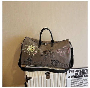 Detail of gray graffiti travel bag with artistic patterns on a white suitcase