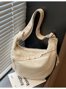 Sac hobo chic en toile blanc cassé avec large bandoulière et détail de pompon