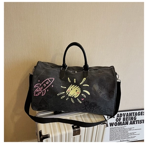 Detail of grey graffiti travel bag with colorful prints placed on a white suitcase