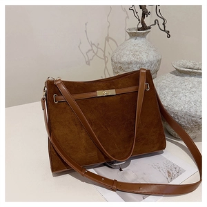 Detail view of large capacity suede shoulder bag with golden metal twist lock closure