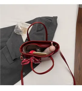 Borsa tote in pelle rosso intenso che mostra l'interno spazioso con ombrello e telefono
