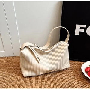 Detail of off-white corduroy tote bag texture with slim straps and metal zipper