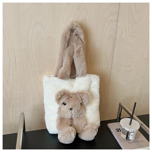 Detail of plush cream tote bag with soft 3D brown teddy bear and textured handles
