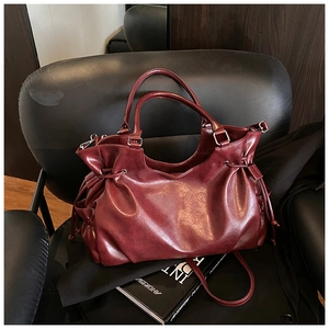 Close-up of a burgundy oil wax leather tote bag on a black chair for daily commuting