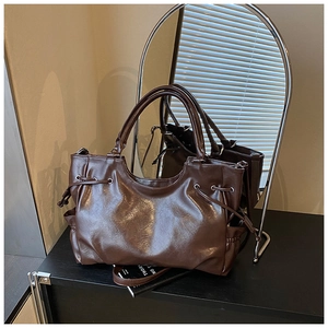 Detail of deep brown oil wax leather tote bag with side drawstring and double handles
