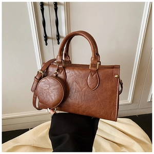 Detail of vintage brown PU leather handbag with detachable coin purse and gold hardware