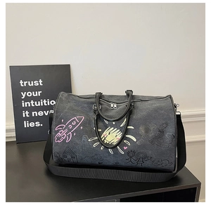 Close-up of graffiti print on dark grey canvas travel bag with rocket and sun patterns