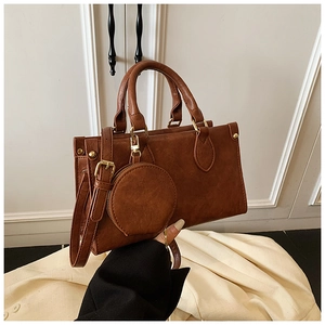 Close-up of brown vintage handbag with gold hardware and a small round coin purse