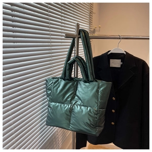 Macro detail of the dark green metallic puffer tote bag with quilted nylon texture