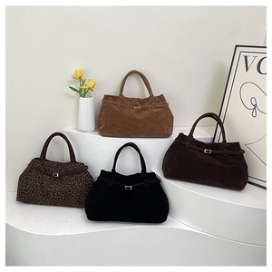 Vista macro de bolsos tote de ante con estampado de leopardo y hebillas metálicas
