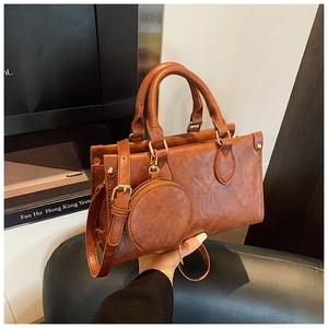 Detail view of the vintage brown PU leather handbag with matching round charm purse and gold hardware