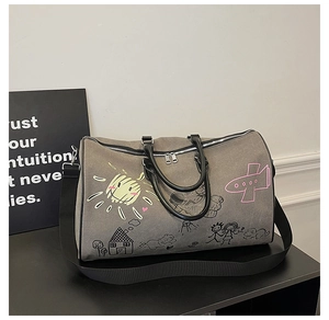 Detail of taupe canvas travel bag featuring colorful graffiti prints and black handles