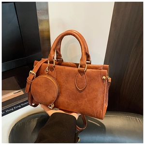 Detail of vintage brown crossbody bag with detachable round coin purse and gold hardware