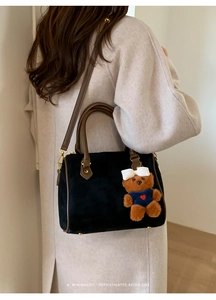 Retro matte black Boston bag with brown leather handles and a cute bear charm accessory