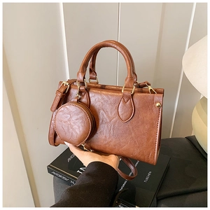 Detailed view of brown retro textured square handbag with detachable round coin purse