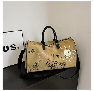 Detail of canvas travel bag with cartoon graffiti prints and adjustable black shoulder strap