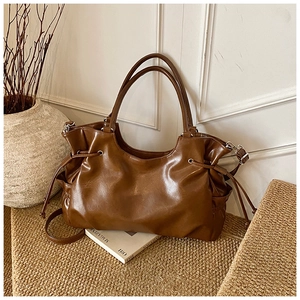 Detail of vintage brown oil wax leather tote showing drawstring pleats and side ties