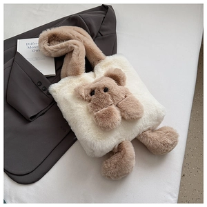 Detail of soft cream plush tote bag featuring a cute brown stuffed bear and fuzzy handles