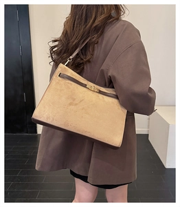Detail of the vintage shoulder bag featuring a metal turn-lock closure and suede texture
