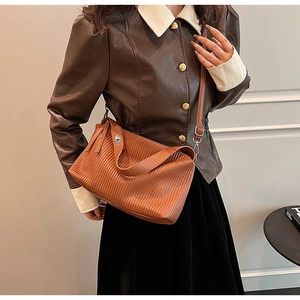 Detailed view of caramel brown pleated leather shoulder bag with chic fringe zipper and strap