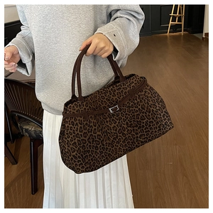 Detalle del bolso tote con estampado de leopardo, gamuza marrón y hebilla metálica