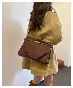 Detailed back view of vintage brown suede shoulder bag with gold twist lock and leather strap